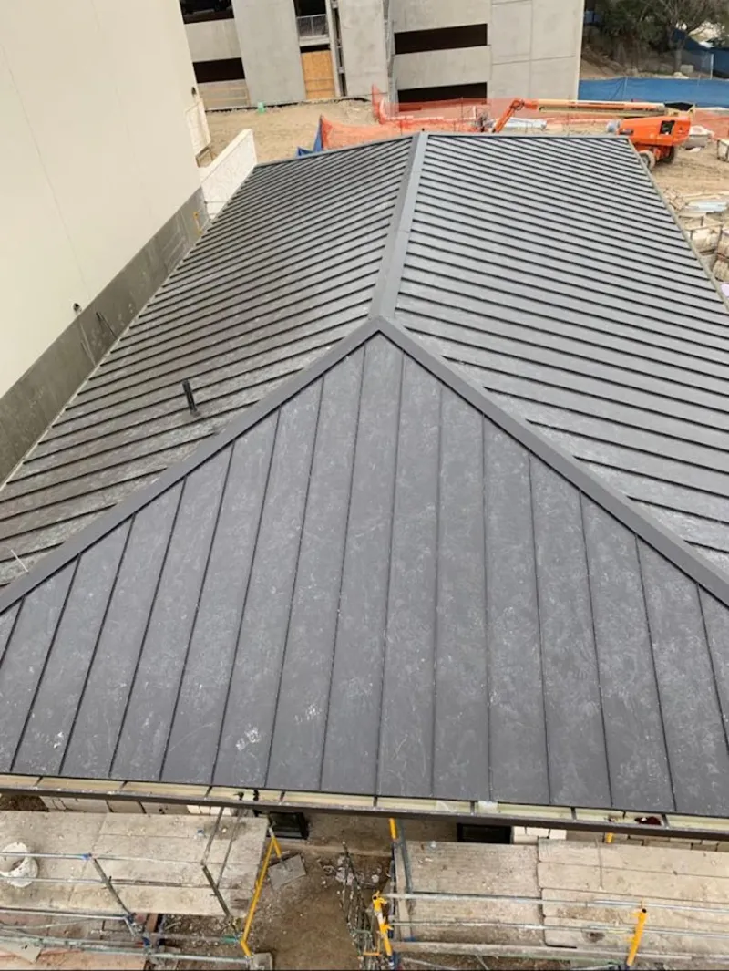 Commercial metal roof construction with crane equipment in Riverside